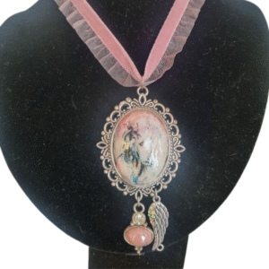 Dusty pink velvet choker with horse pendant, angel wing charm, and gemstone detail on black display