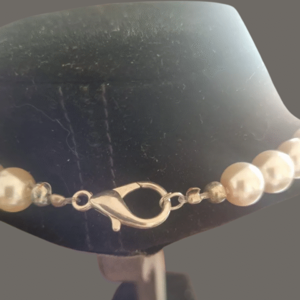 Lobster clasp and silver findings on pearl shell necklace with round beads